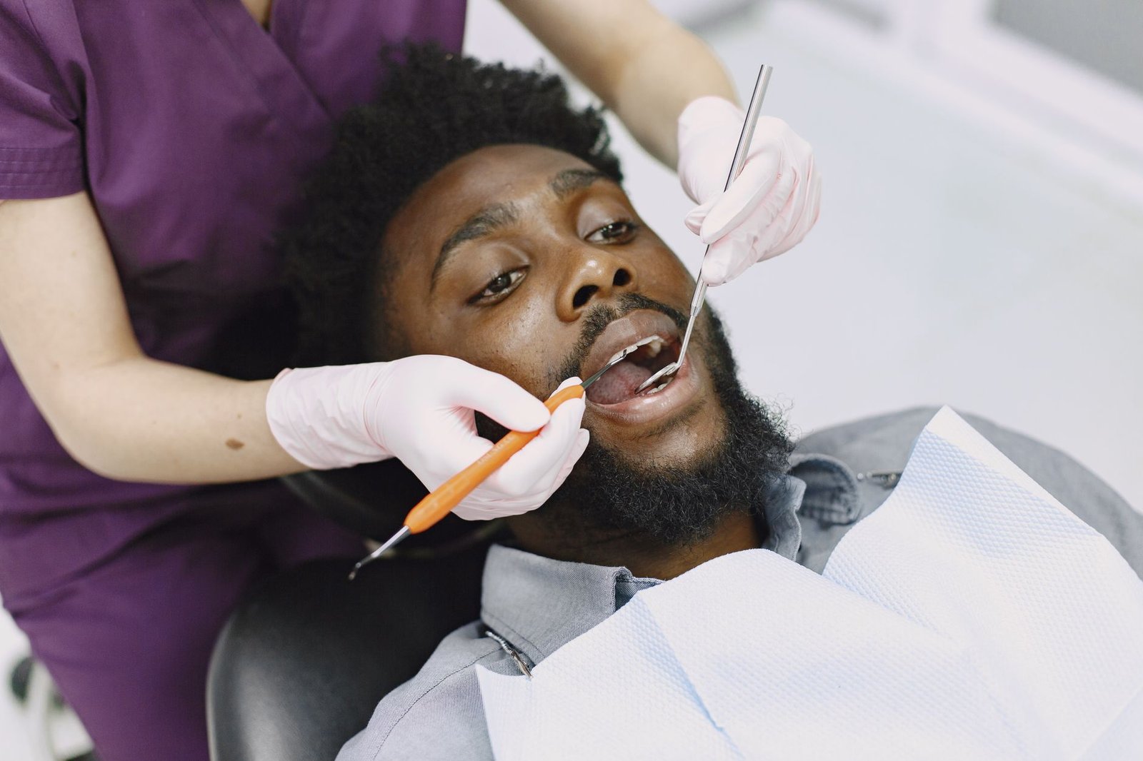 Dentist examining a man's teeth and gums during a routine checkup