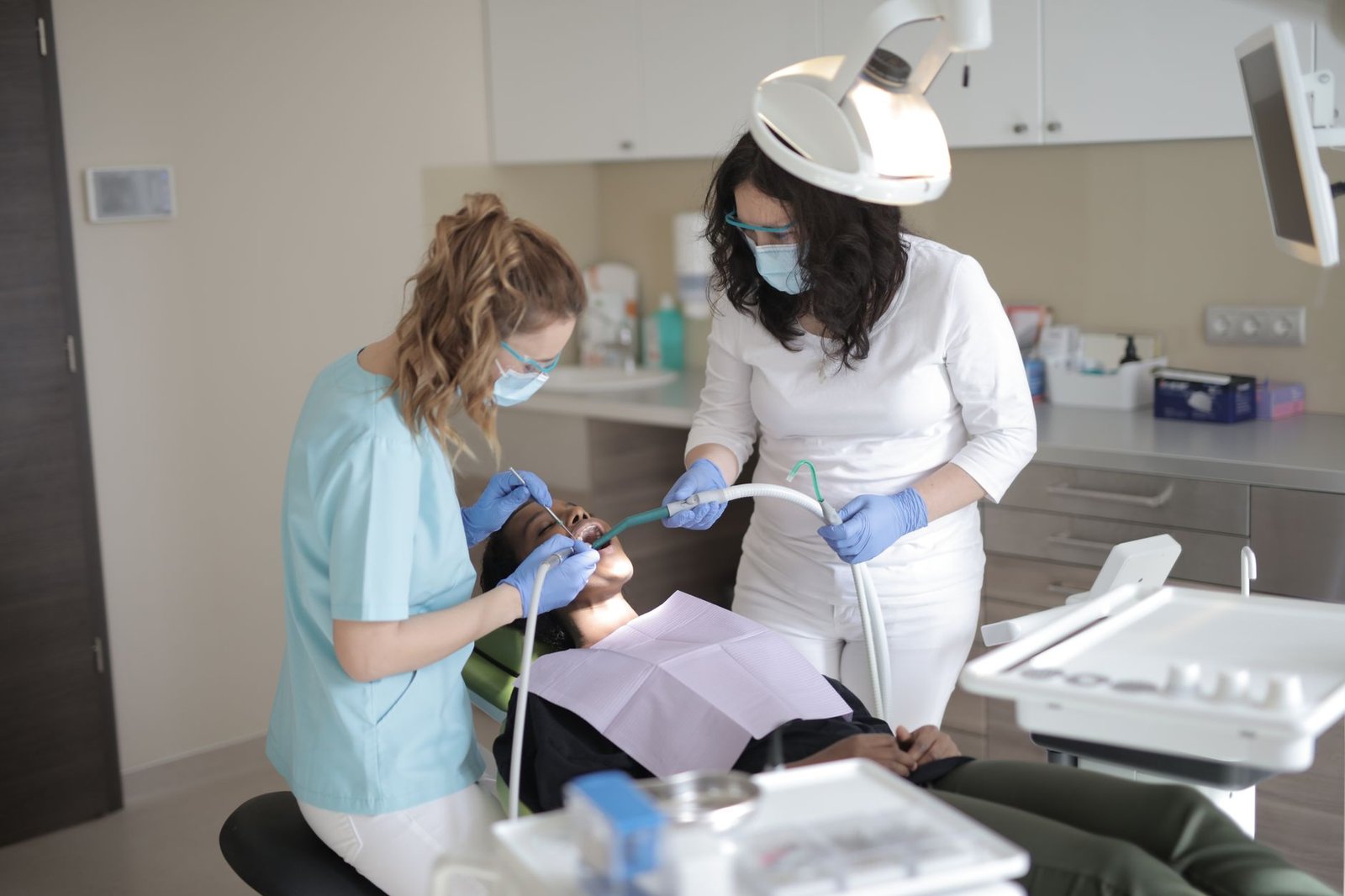 Dentist and assistant examining a patient's teeth in a dental clinic
