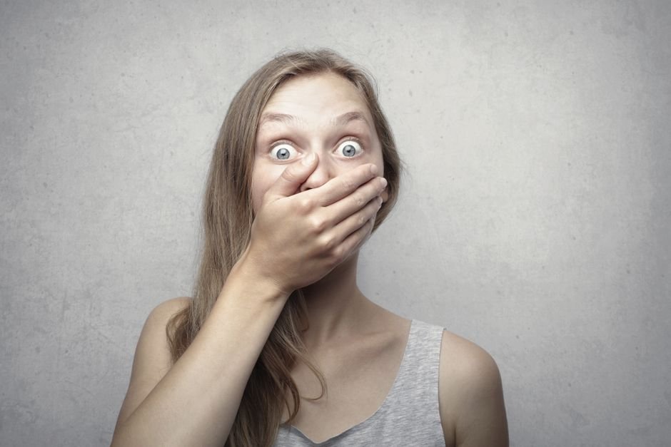 Woman covering her mouth self-consciously, illustrating concern about bad breath